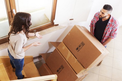 Professional piano movers navigating a narrow staircase in New Cross